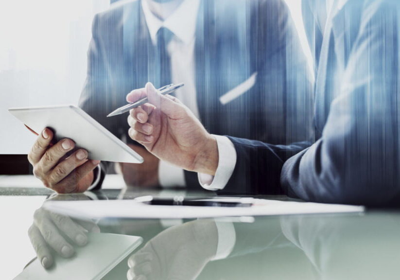 Corporate businessmen working on tablet at office